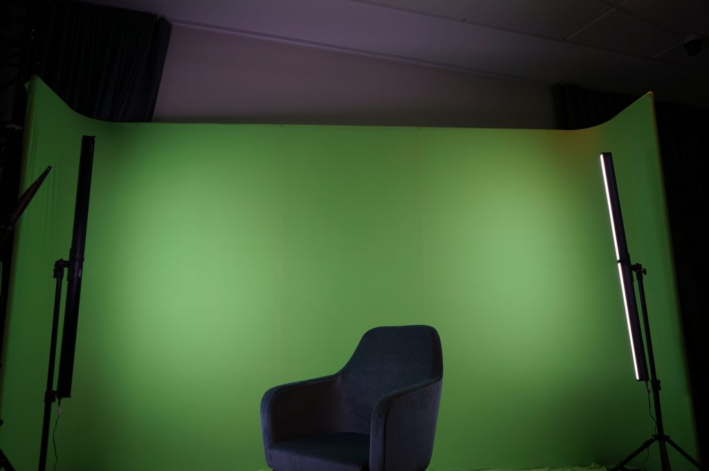 A chair sitting against a green screen for professional event production